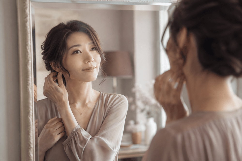 鏡で身だしなみを整える女性の写真
